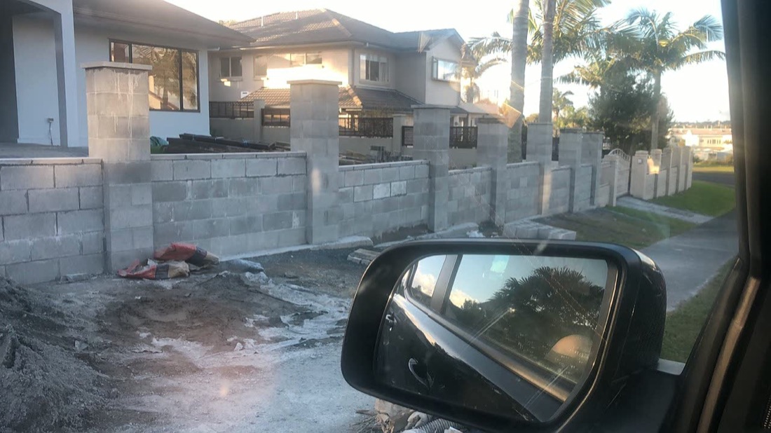 Block boundary wall preparation beside a residential driveway