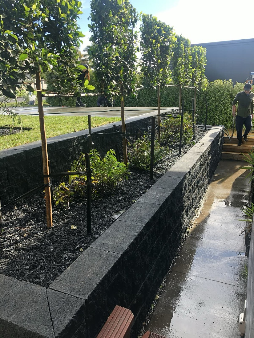Block retaining wall with planting bed and side access