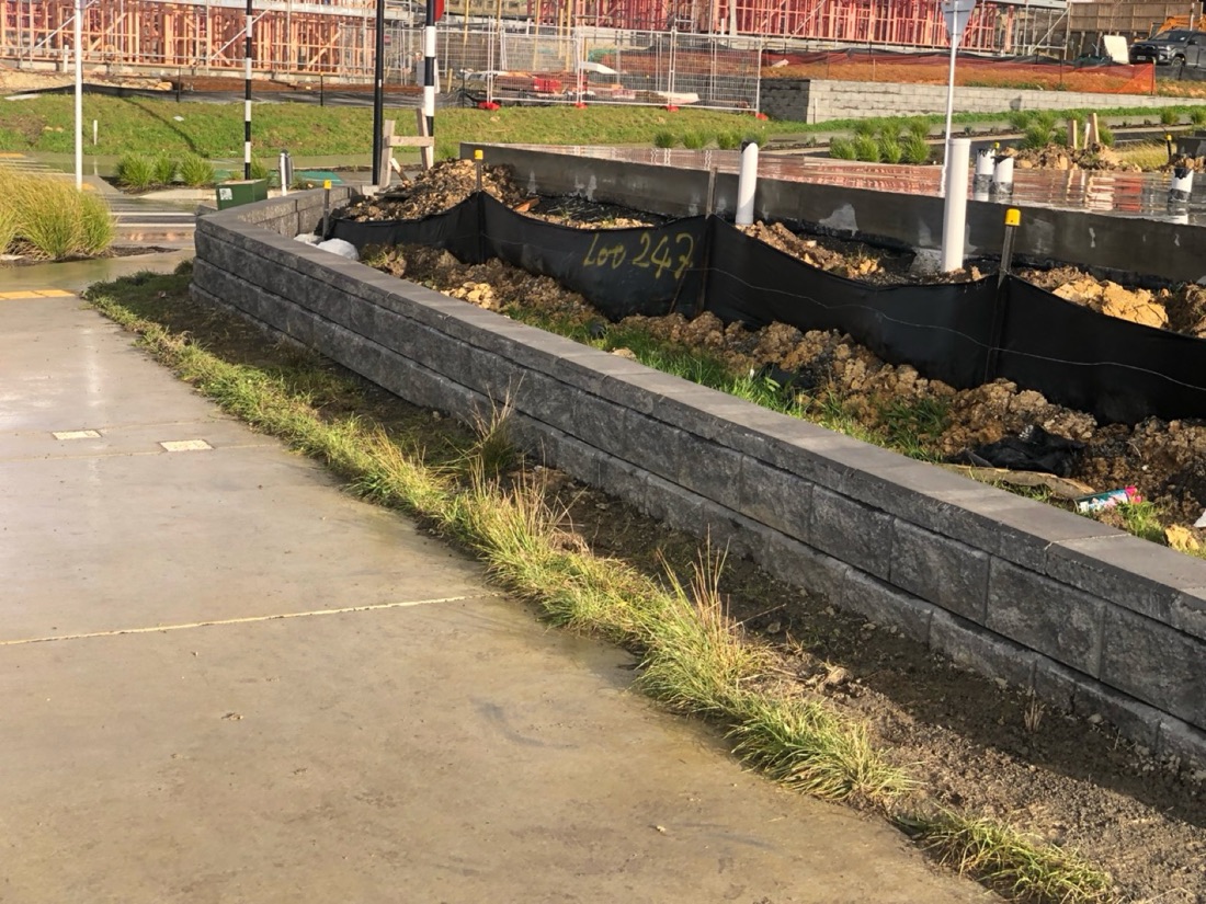 Block retaining wall beside landscaping and footpath