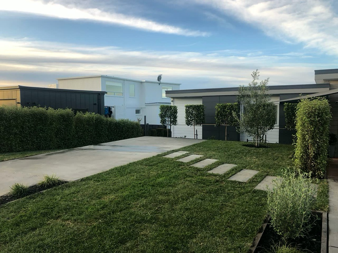 Concrete driveway with lawn, planting and stepping stone path