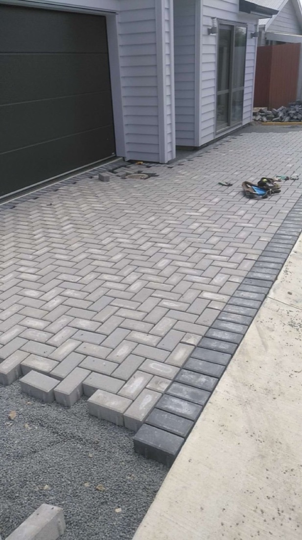 Herringbone paver driveway beside a residential garage