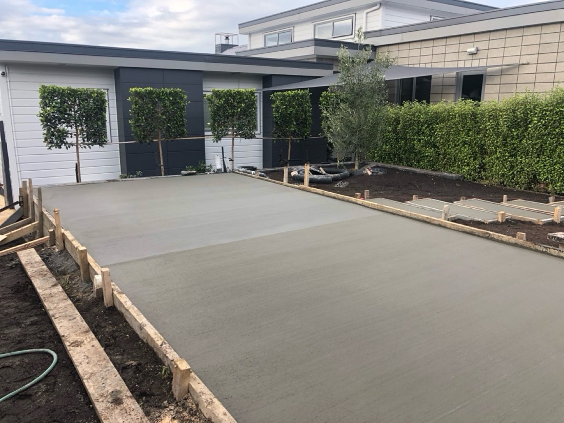 Residential concrete pad with garden edging and planting areas