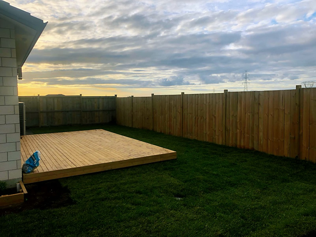Raised timber deck with boundary fence and lawn