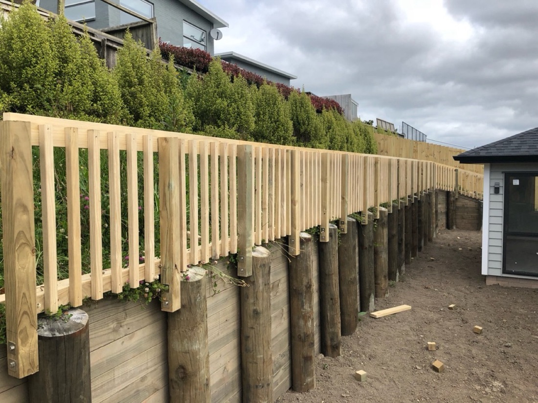 Timber retaining wall with balustrade along a sloped garden area