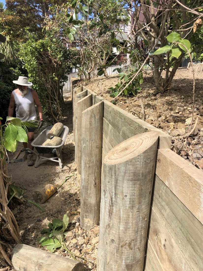 Timber retaining wall construction on a sloped garden bank
