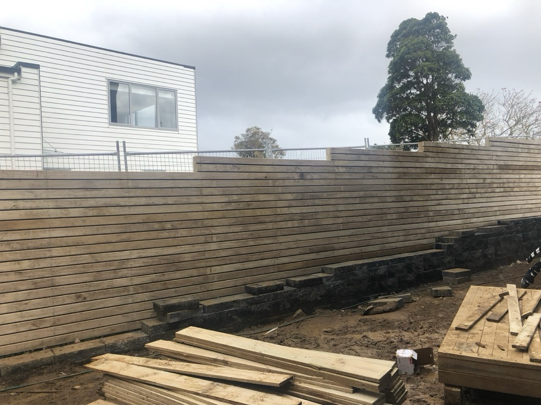 Long timber retaining wall with construction materials in the foreground